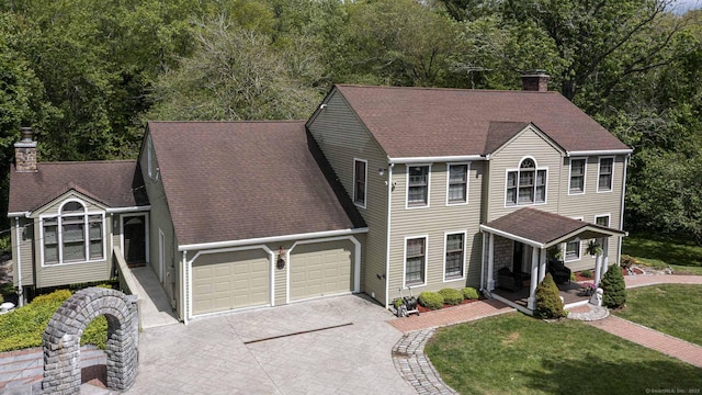 61 Baldwin Brook Rd, Canterbury, CT 06331 - colonial-style house featuring a chimney, an attached garage, driveway, a front lawn, and roof with shingles