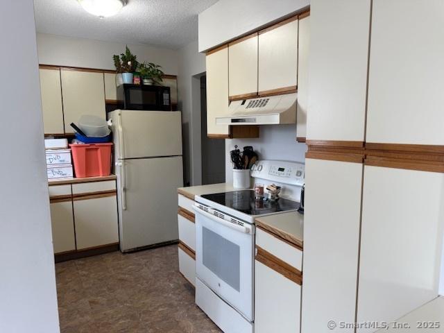9 Staffordshire Commons Dr Unit 9, Wallingford, CT 06492 - kitchen featuring white appliances, under cabinet range hood, white cabinetry, light countertops, and a textured ceiling