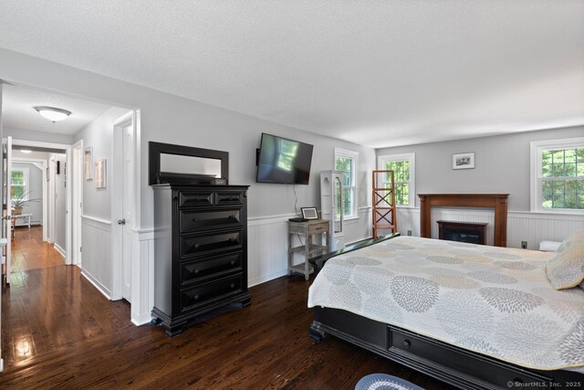 3 Colonial Dr, Clinton, CT 06413 - bedroom featuring dark wood-style flooring, wainscoting, and a fireplace