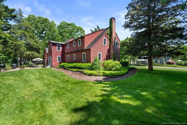 3 Colonial Dr, Clinton, CT 06413 - view of side of home featuring a chimney and a yard