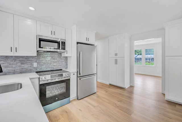189 Tashua Rd, Trumbull, CT 06611 - kitchen with stainless steel appliances, light wood-type flooring, light countertops, white cabinets, and recessed lighting