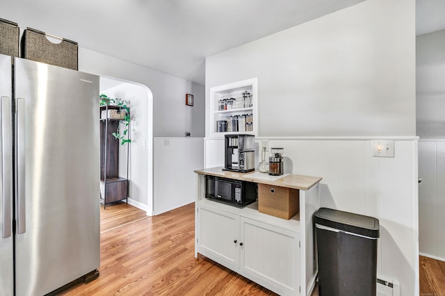 55 Osborne St, Stratford, CT 06614 - kitchen featuring freestanding refrigerator, black microwave, light wood-style floors, a wainscoted wall, and white cabinets
