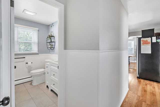 55 Osborne St, Stratford, CT 06614 - hall with baseboard heating, wainscoting, and light wood-style floors