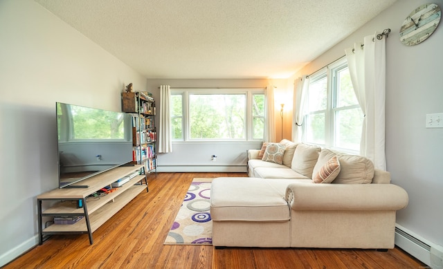 1 Trumbull St, Vernon, CT 06066 - living room featuring a baseboard heating unit, a textured ceiling, healthy amount of natural light, and wood finished floors