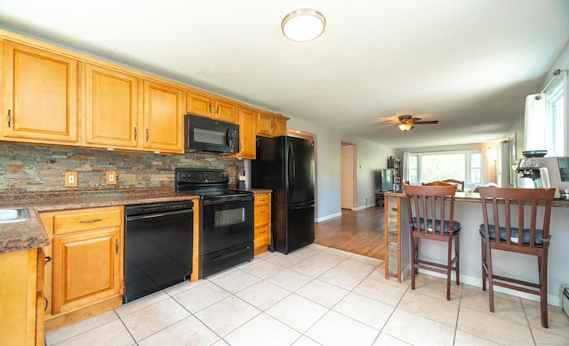 1 Trumbull St, Vernon, CT 06066 - kitchen with black appliances, decorative backsplash, ceiling fan, baseboards, and a kitchen bar