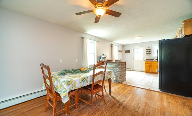 1 Trumbull St, Vernon, CT 06066 - dining room featuring a baseboard radiator, a ceiling fan, light wood-style floors, and a textured ceiling