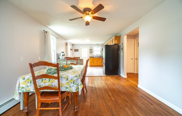 1 Trumbull St, Vernon, CT 06066 - dining room with ceiling fan, baseboard heating, light wood-type flooring, and a textured ceiling