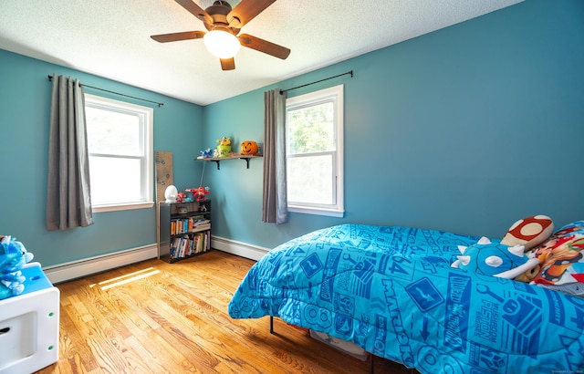1 Trumbull St, Vernon, CT 06066 - bedroom featuring baseboard heating, a baseboard radiator, wood finished floors, a textured ceiling, and ceiling fan