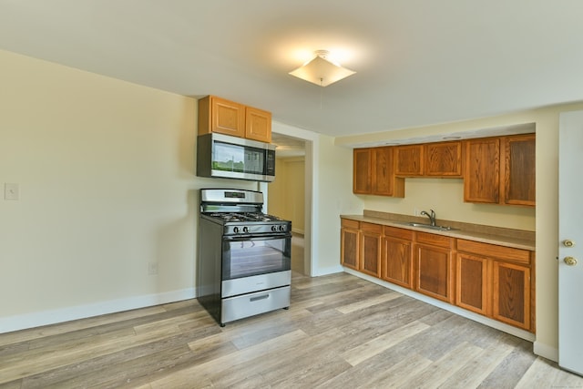96 Water St, Killingly, CT 06239 - kitchen featuring stainless steel appliances, a sink, light wood finished floors, and brown cabinets