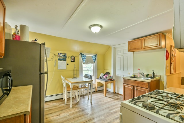 96 Water St, Killingly, CT 06239 - kitchen with a sink, white gas stove, light wood-type flooring, a baseboard heating unit, and brown cabinetry