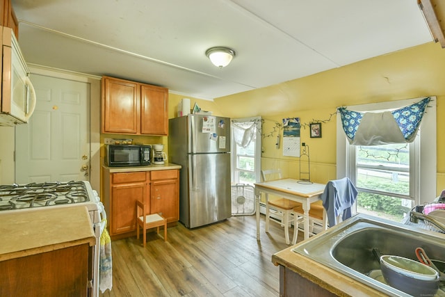 96 Water St, Killingly, CT 06239 - kitchen featuring white appliances, vaulted ceiling, light wood-style flooring, a sink, and light countertops