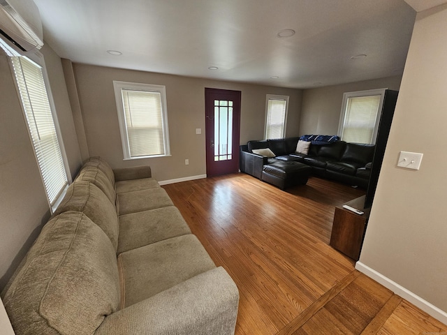 216 Bunker Hill Ave, Waterbury, CT 06708 - living area featuring a wall unit AC, wood finished floors, healthy amount of natural light, baseboards, and recessed lighting