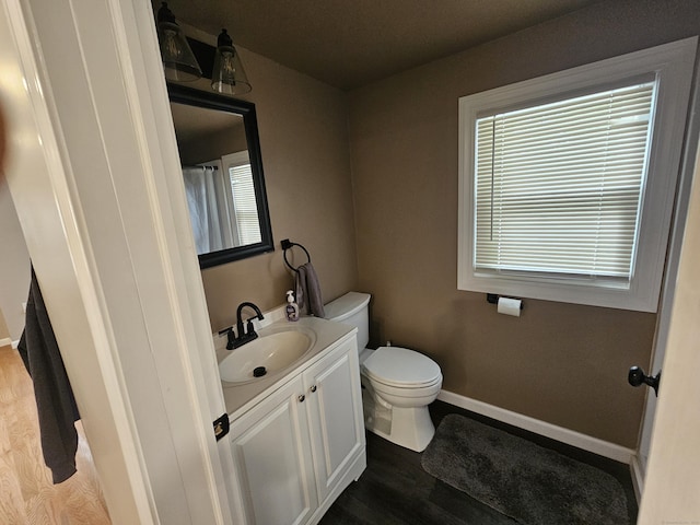 216 Bunker Hill Ave, Waterbury, CT 06708 - bathroom featuring vanity, toilet, wood finished floors, and baseboards