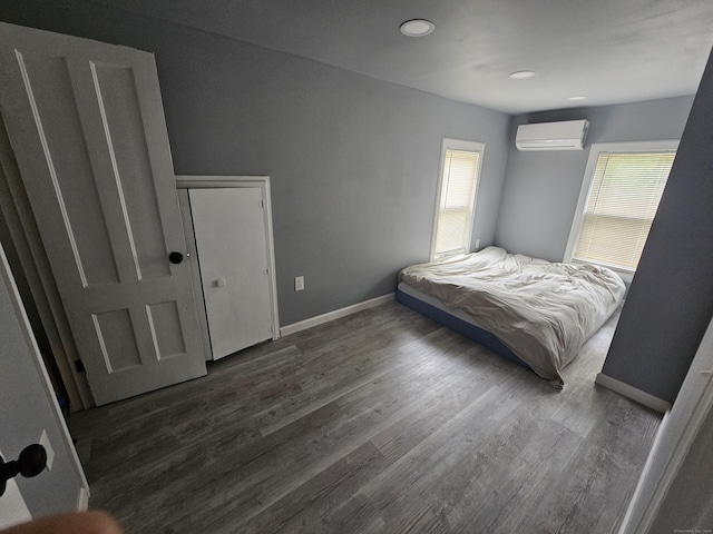 216 Bunker Hill Ave, Waterbury, CT 06708 - bedroom with a wall unit AC, multiple windows, wood finished floors, and recessed lighting