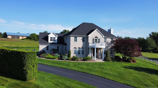 197 Shadow Pond Ln, Suffield, CT 06078 - georgian-style home featuring a balcony, a front yard, a chimney, and brick siding
