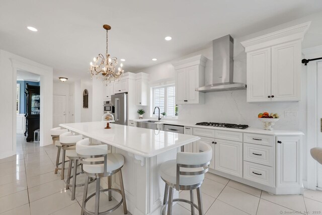 197 Shadow Pond Ln, Suffield, CT 06078 - kitchen featuring wall chimney range hood, light tile patterned floors, appliances with stainless steel finishes, a center island, and recessed lighting