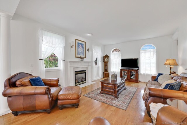 197 Shadow Pond Ln, Suffield, CT 06078 - living room featuring light wood-style flooring, a premium fireplace, and decorative columns