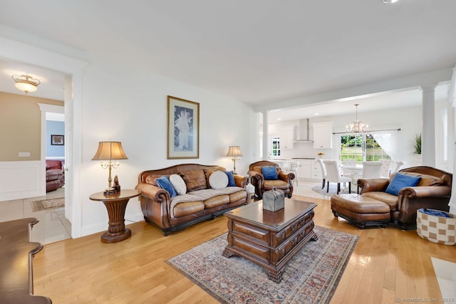 197 Shadow Pond Ln, Suffield, CT 06078 - living room featuring light wood-type flooring, a chandelier, and a wainscoted wall