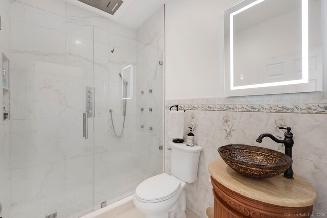 197 Shadow Pond Ln, Suffield, CT 06078 - bathroom with a marble finish shower, toilet, vanity, and tile walls