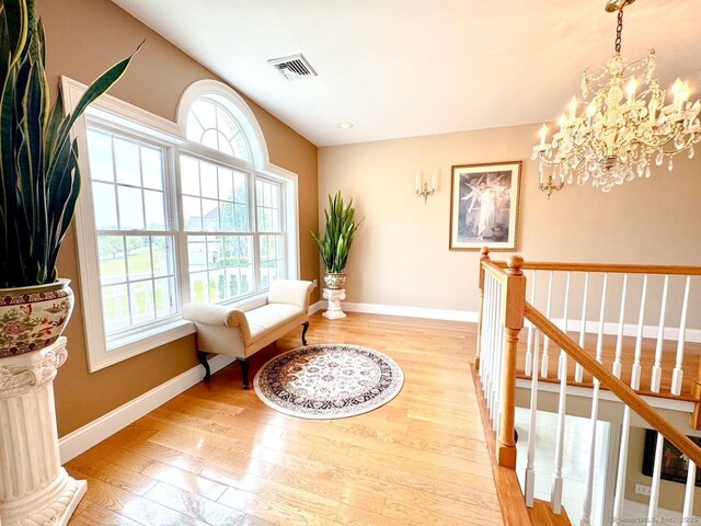 197 Shadow Pond Ln, Suffield, CT 06078 - living area featuring light wood-style flooring, a chandelier, baseboards, and an upstairs landing