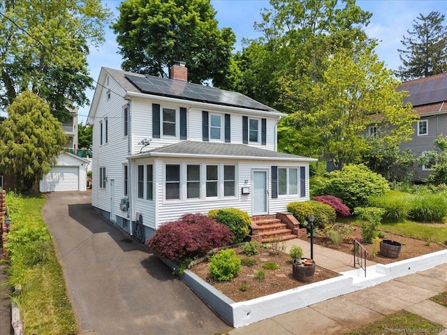 37 Park Ave, Hamden, CT 06517 - view of front facade with a chimney, a detached garage, an outbuilding, roof mounted solar panels, and entry steps