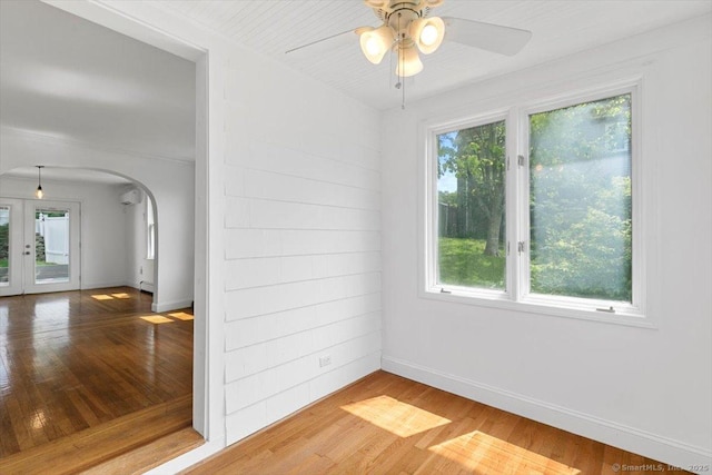37 Park Ave, Hamden, CT 06517 - unfurnished room featuring arched walkways, a ceiling fan, wood finished floors, baseboards, and a wall mounted air conditioner