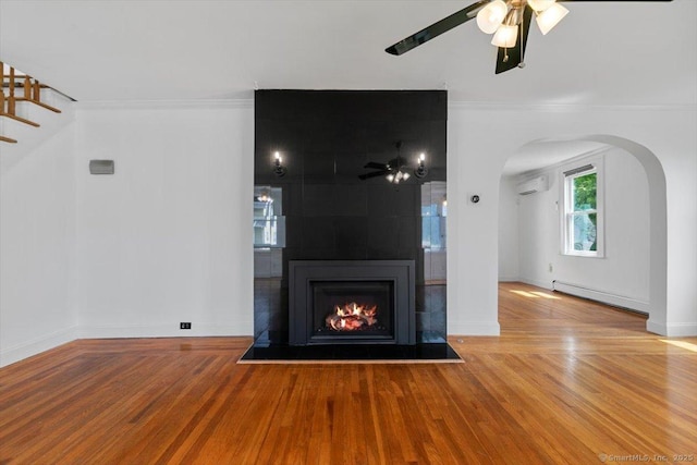 37 Park Ave, Hamden, CT 06517 - unfurnished living room with baseboard heating, a ceiling fan, arched walkways, wood finished floors, and crown molding