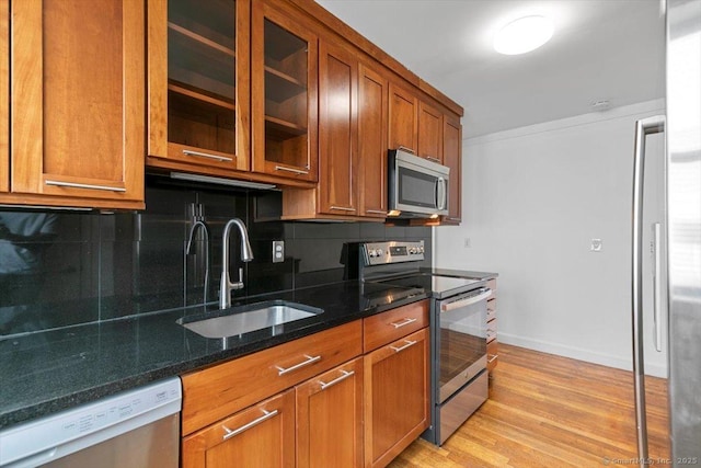 37 Park Ave, Hamden, CT 06517 - kitchen featuring stainless steel appliances, a sink, decorative backsplash, brown cabinets, and dark stone counters