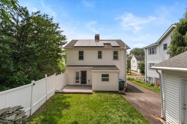 37 Park Ave, Hamden, CT 06517 - rear view of property featuring roof mounted solar panels, french doors, and a chimney