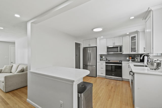 63 Paul Ter, Southington, CT 06489 - kitchen featuring stainless steel appliances, a sink, light wood-style floors, recessed lighting, and tasteful backsplash