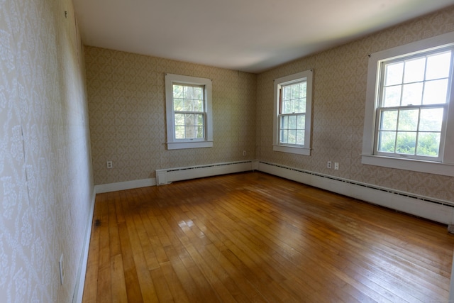 121 Warren Ave, Groton, CT 06355 - spare room featuring wood-type flooring, baseboard heating, wallpapered walls, and baseboards