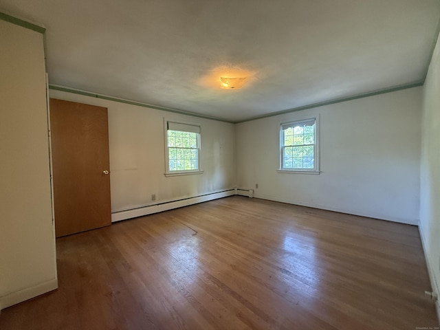 49 Carver Cir, Simsbury, CT 06070 - spare room featuring a baseboard heating unit, ornamental molding, healthy amount of natural light, and wood finished floors