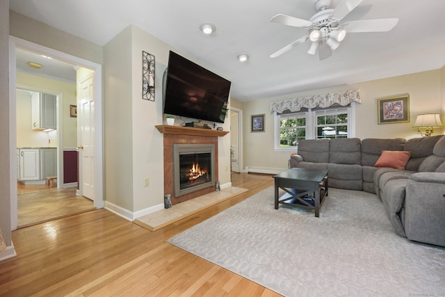 26 Dale Rd, Trumbull, CT 06611 - living area featuring baseboard heating, a fireplace, wood finished floors, a ceiling fan, and baseboards