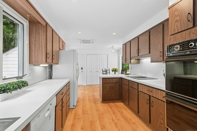 1111 Merwins Ln, Fairfield, CT 06824 - kitchen with black appliances, light countertops, a peninsula, light wood-style flooring, and brown cabinets