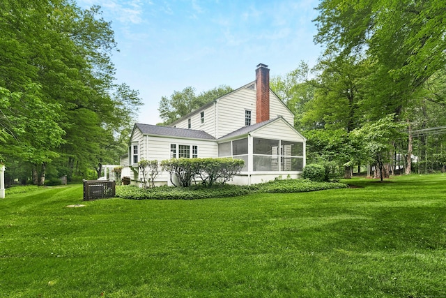 1111 Merwins Ln, Fairfield, CT 06824 - rear view of house with a sunroom, a chimney, and a lawn