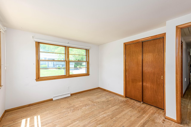 77 Hesse Rd, Hamden, CT 06517 - unfurnished bedroom with a baseboard radiator, light wood-style flooring, a closet, and baseboards