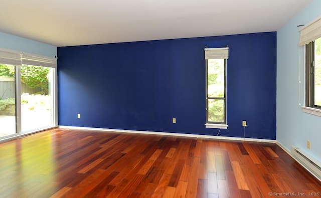 926 Heritage Vlg Unit B, Southbury, CT 06488 - spare room featuring a baseboard heating unit, wood finished floors, plenty of natural light, and baseboards