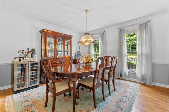 39 Munn Rd, Southbury, CT 06488 - dining room with wine cooler, a chandelier, crown molding, light wood finished floors, and baseboards