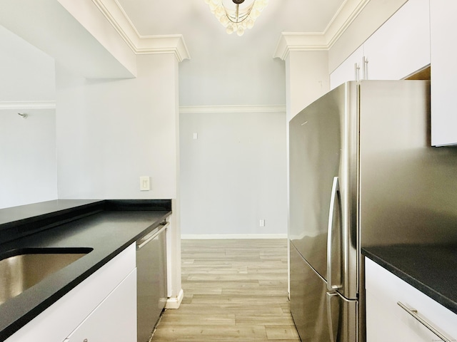25 Forest St Unit 11A, Stamford, CT 06901 - kitchen featuring stainless steel appliances, ornamental molding, light wood finished floors, white cabinetry, and dark countertops