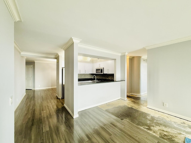 25 Forest St Unit 11A, Stamford, CT 06901 - kitchen featuring stainless steel microwave, ornamental molding, tasteful backsplash, white cabinets, and dark countertops