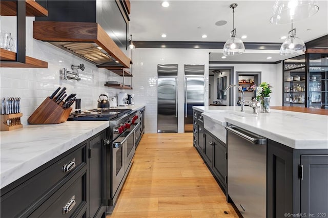 66 High St Unit 17, Guilford, CT 06437 - kitchen featuring appliances with stainless steel finishes, a sink, dark cabinetry, and tasteful backsplash