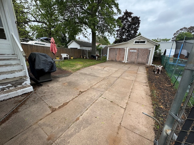 165 Dodge Ave, East Haven, CT 06512 - view of patio featuring a detached garage, a grill, and an outbuilding