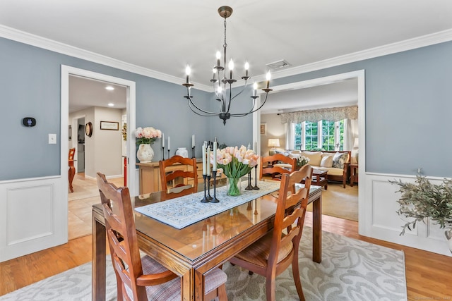 17 Stockade Rd, Simsbury, CT 06092 - dining space featuring a chandelier, ornamental molding, wainscoting, light wood finished floors, and a decorative wall