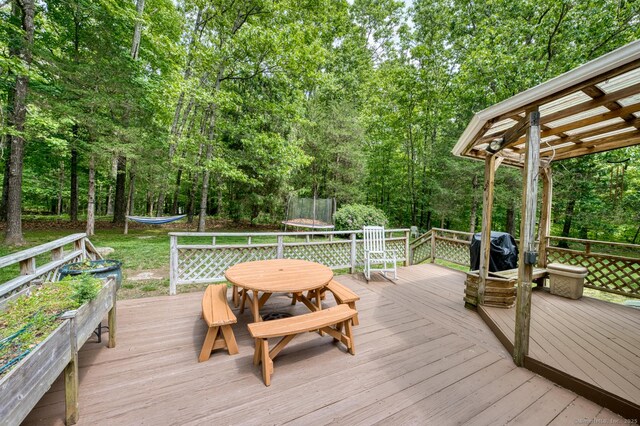 24 Marbella Ln, Tolland, CT 06084 - deck featuring a trampoline, outdoor dining area, and grilling area