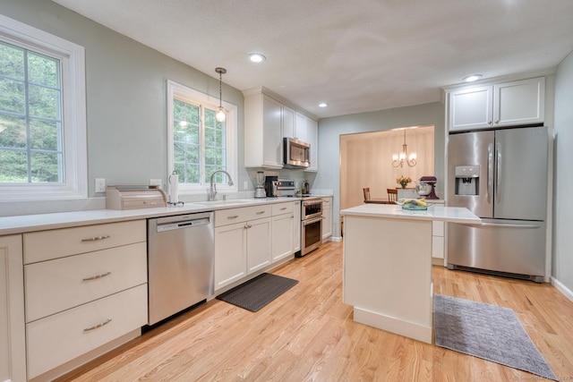 24 Marbella Ln, Tolland, CT 06084 - kitchen featuring stainless steel appliances, a sink, light wood finished floors, light countertops, and white cabinets