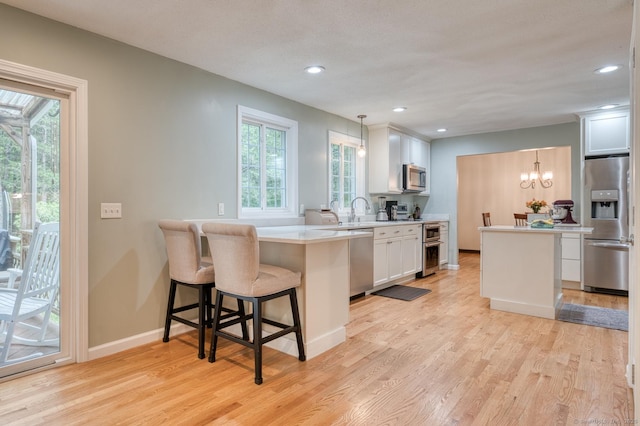 24 Marbella Ln, Tolland, CT 06084 - kitchen with stainless steel appliances, white cabinetry, light wood-style floors, light countertops, and recessed lighting