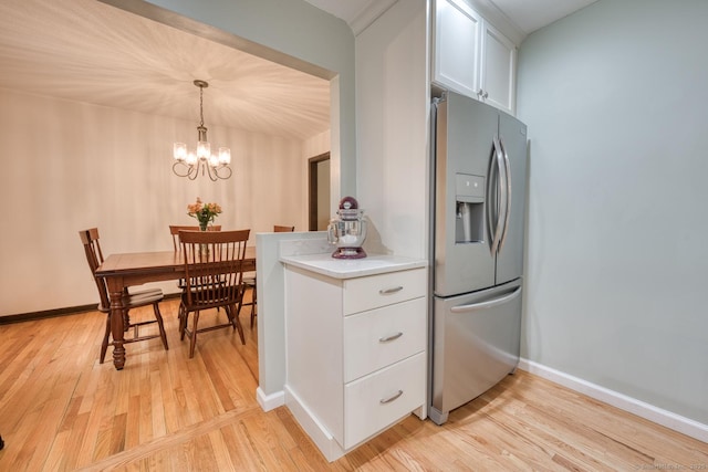 24 Marbella Ln, Tolland, CT 06084 - kitchen featuring stainless steel refrigerator with ice dispenser, light wood finished floors, light countertops, white cabinets, and a chandelier