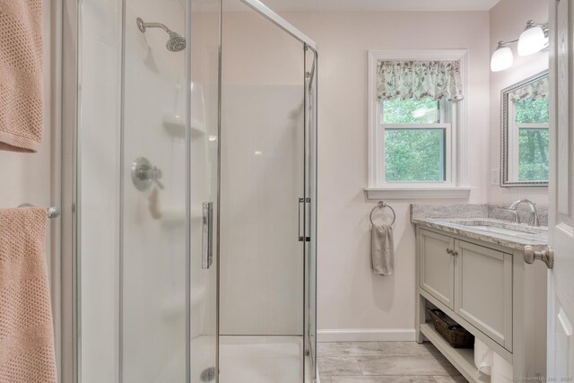 24 Marbella Ln, Tolland, CT 06084 - full bathroom with a stall shower, vanity, baseboards, and wood finished floors