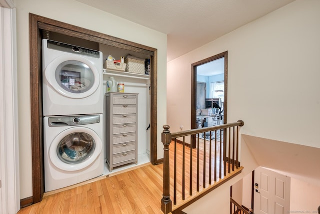 24 Marbella Ln, Tolland, CT 06084 - laundry area with stacked washing machine and dryer and light wood-style flooring