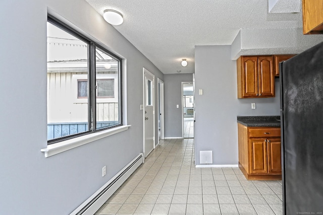 60 Plainfield Ave Unit 14, West Haven, CT 06516 - kitchen featuring freestanding refrigerator, brown cabinetry, healthy amount of natural light, and a textured ceiling